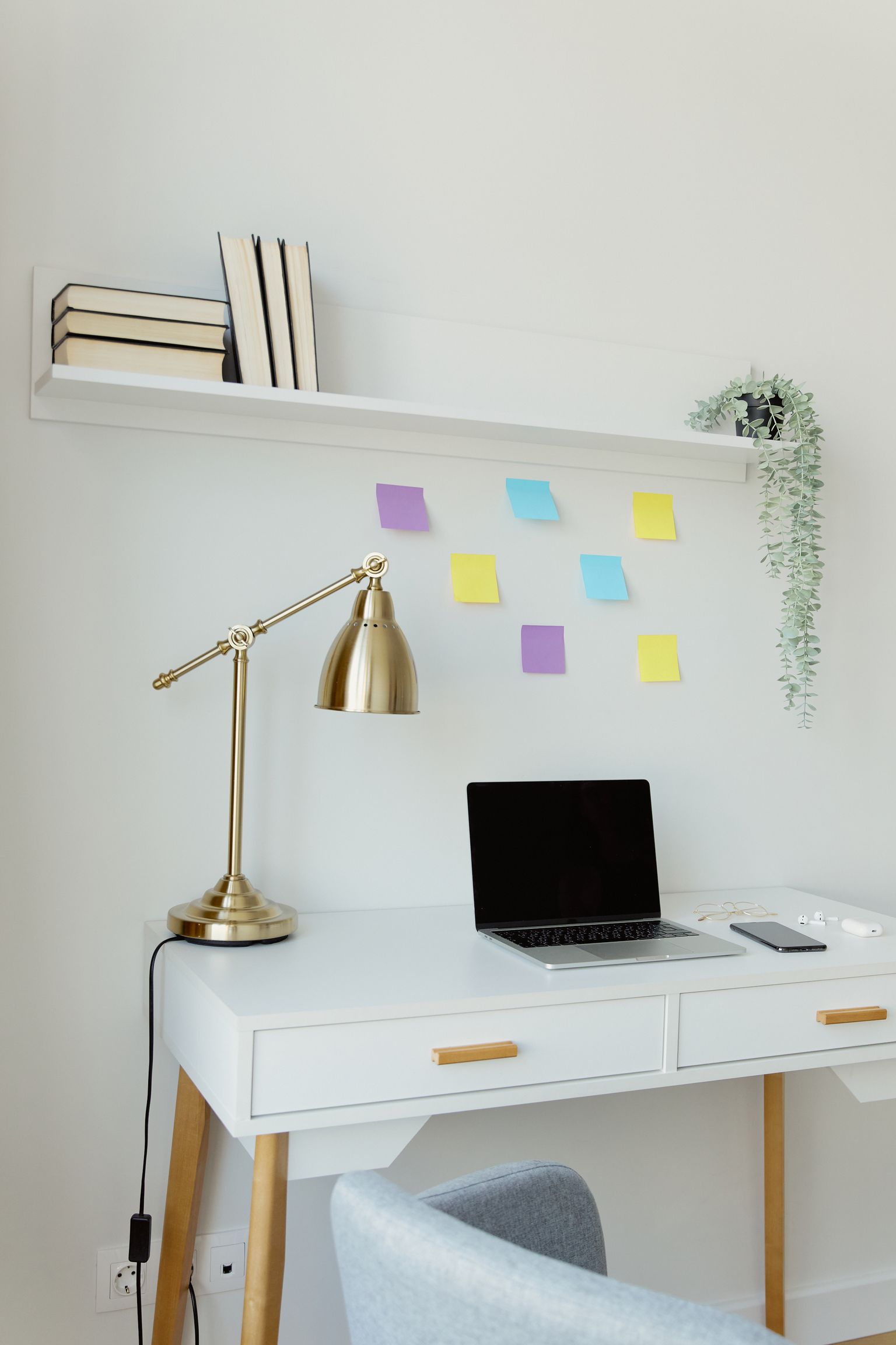 A photographed compact workspace with wall decor and shelf
